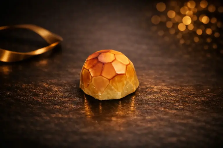 Pralinka Diamant TIA je z belgické bílé čokolády se smetanovou bíločokoládovou náplní s kávovou příchutí.
